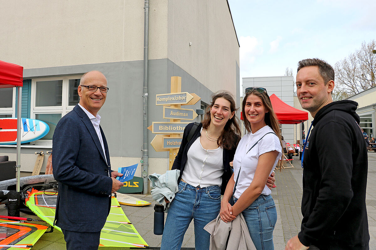 Ein Professor mit Studierenden im Gespräch auf dem Mensavorplatz